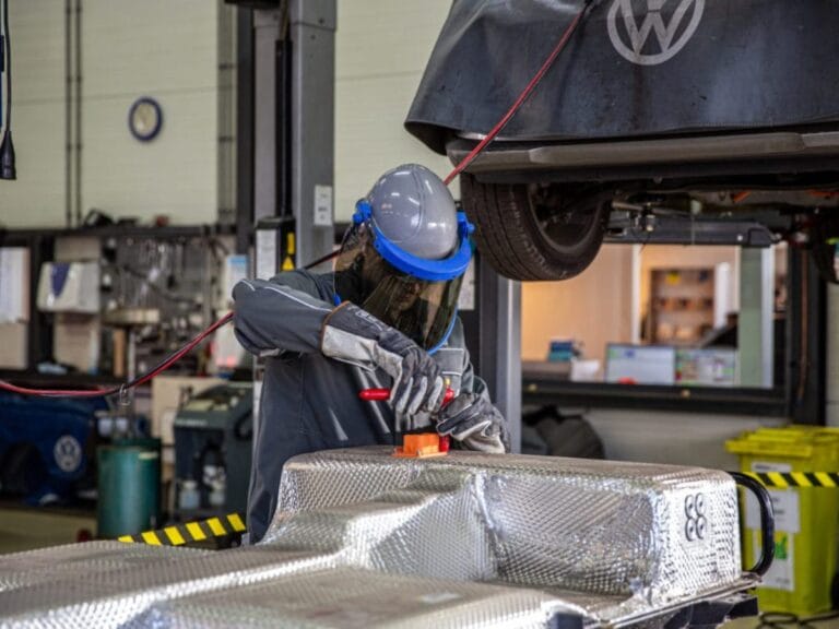 Monteur werkt aan accupakket in autogarage