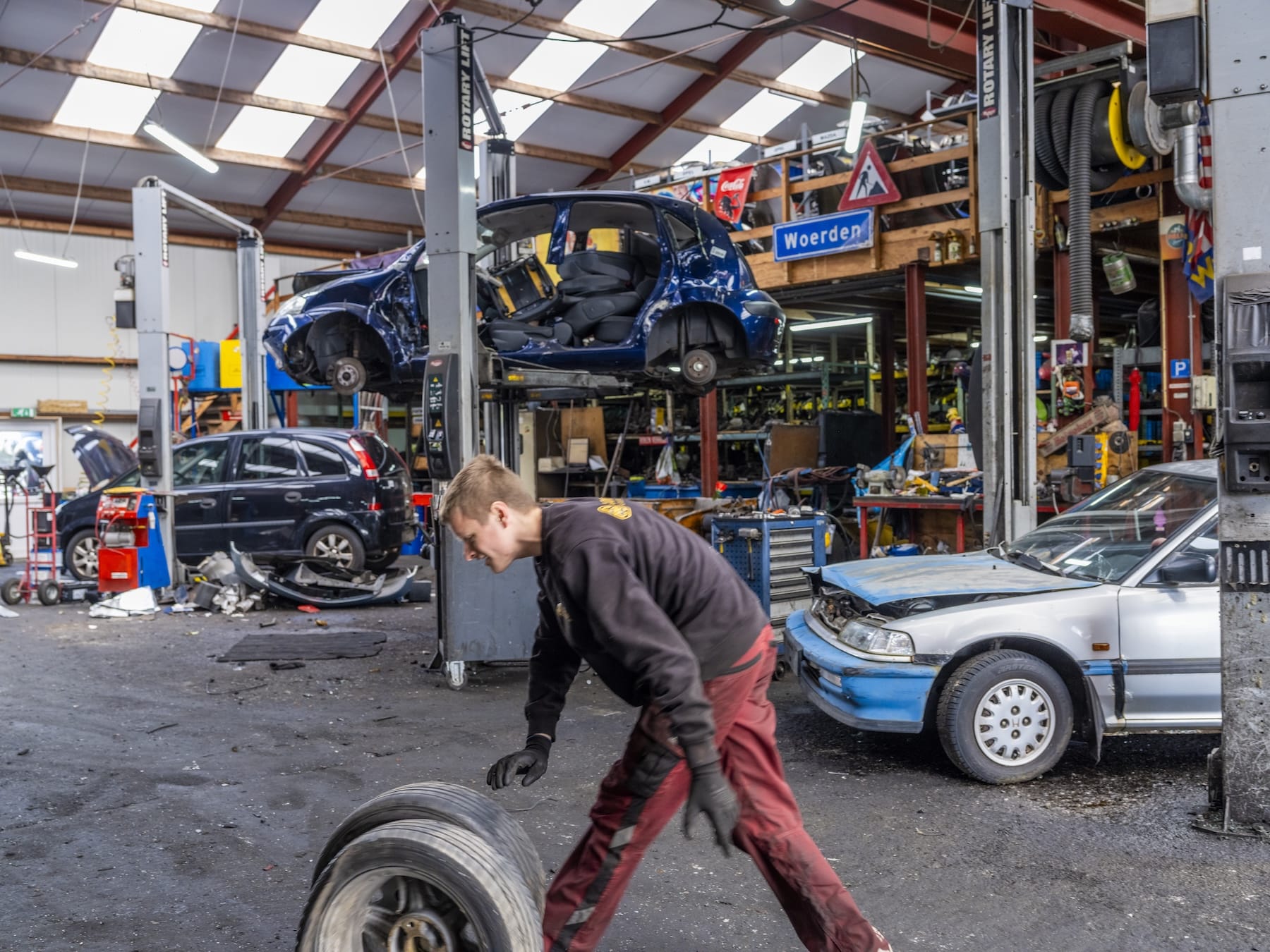 Monteur rolt band in autogarage met hefbruggen
