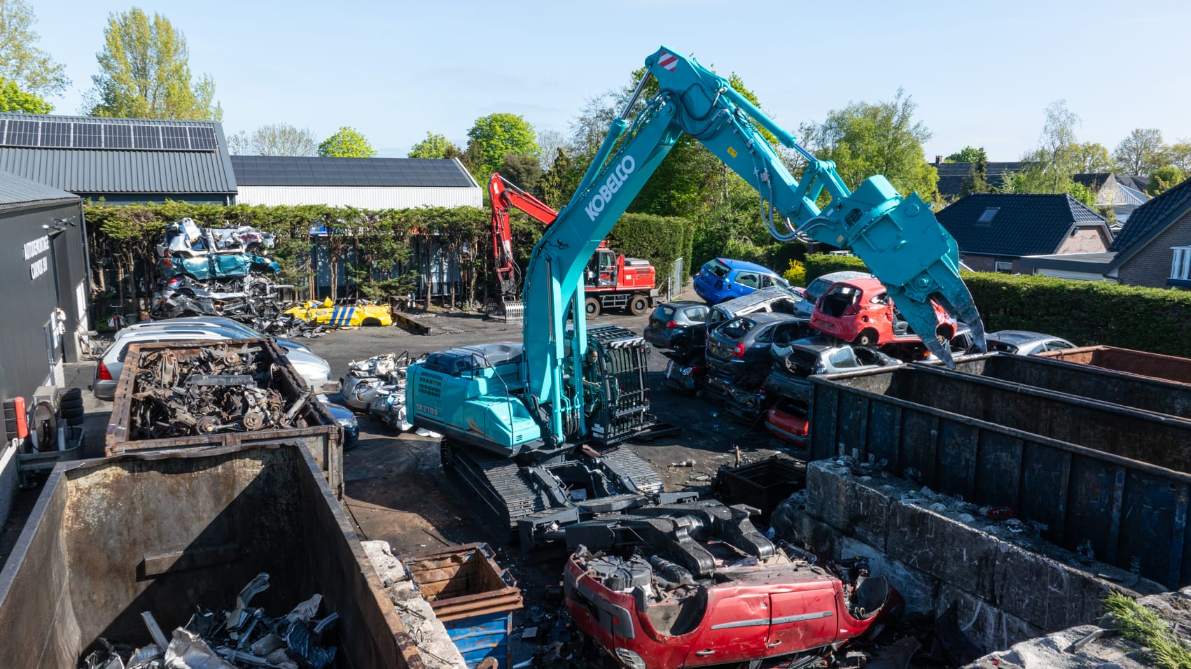 Graafmachine verplettert auto's op autosloperij