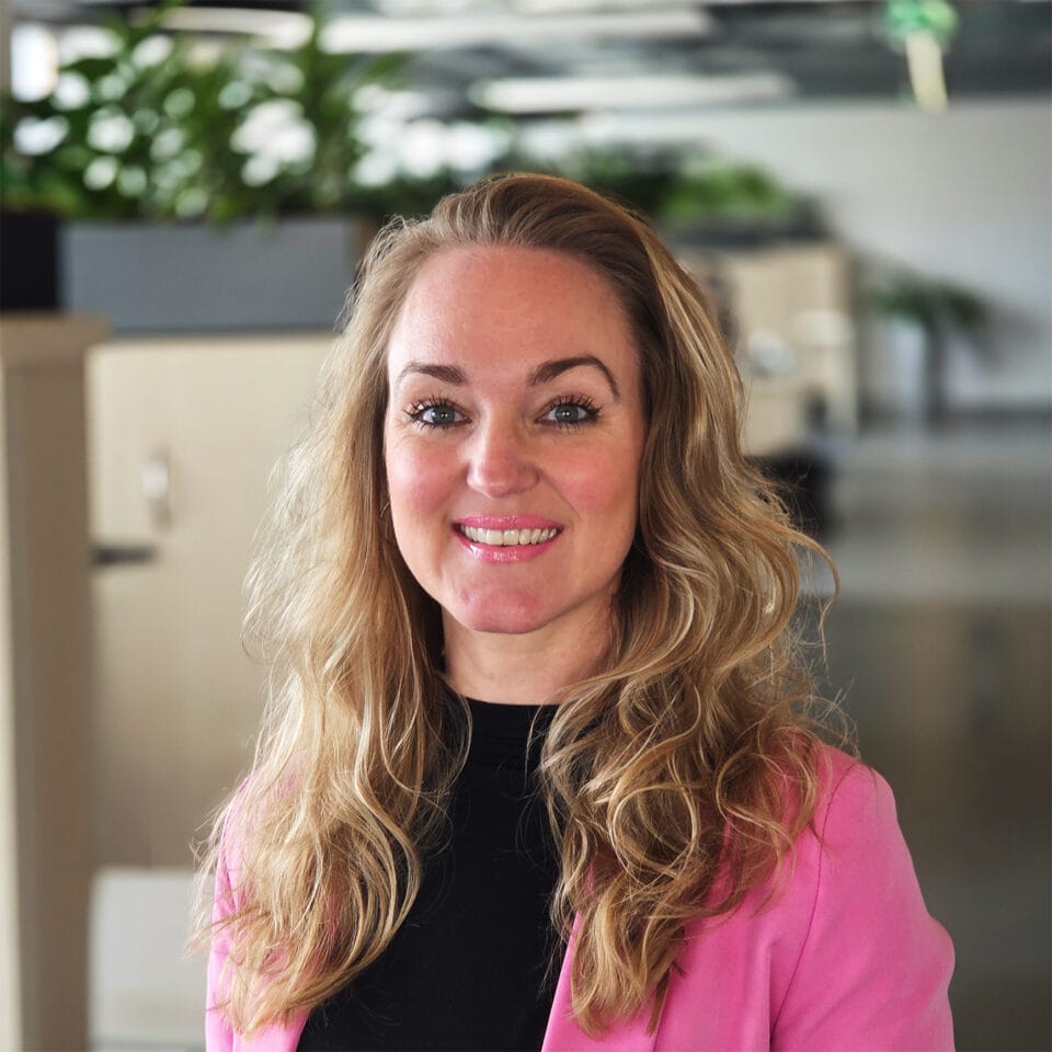Vrouw glimlacht in moderne kantooromgeving.