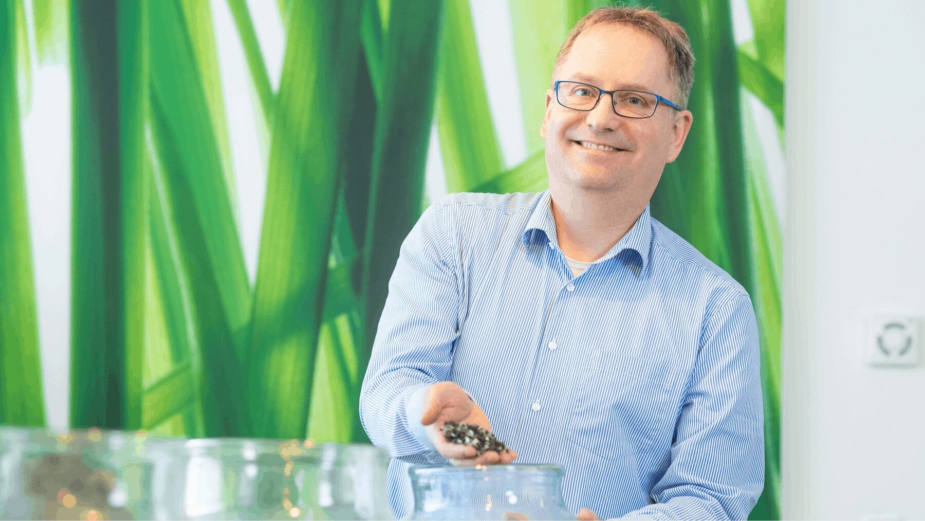 Man met bril houdt zaden boven pot