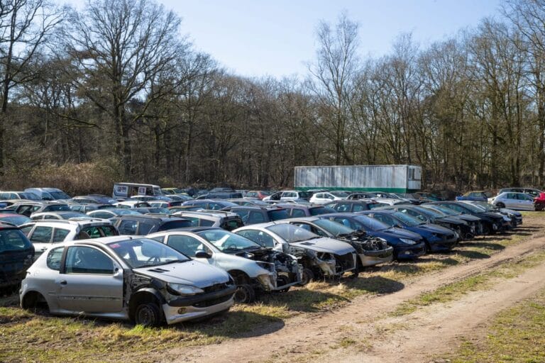 autodemontagebedrijf met beschadigde voertuigen, waaronder enkele Peugeots 206